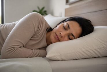 Persona durmiendo de lado con la cabeza y el cuello alineados sobre una almohada