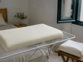 Almohada viscoelástica extendida junto a una ventana, con la funda retirada para airearla
