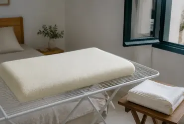 Almohada viscoelástica extendida junto a una ventana, con la funda retirada para airearla