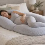 Mujer embarazada descansando de lado con una almohada de embarazo en forma de U