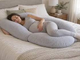 Mujer embarazada descansando de lado con una almohada de embarazo en forma de U