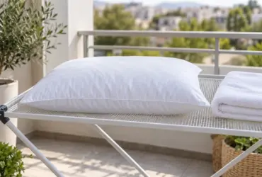 Almohada blanca secándose en horizontal sobre una rejilla ventilada